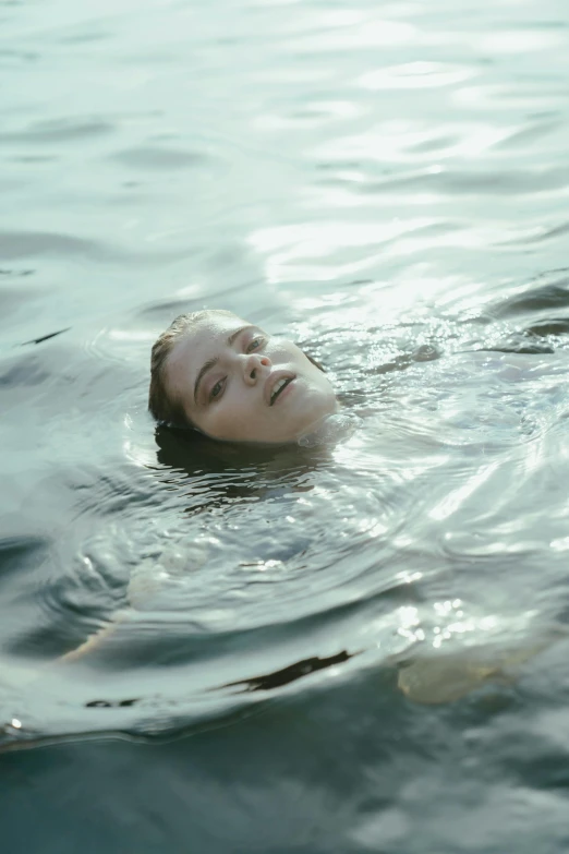 a woman floating on top of a body of water, inspired by Elsa Bleda, unsplash, renaissance, headshot, still from film, sydney sweeney, phoebe tonkin