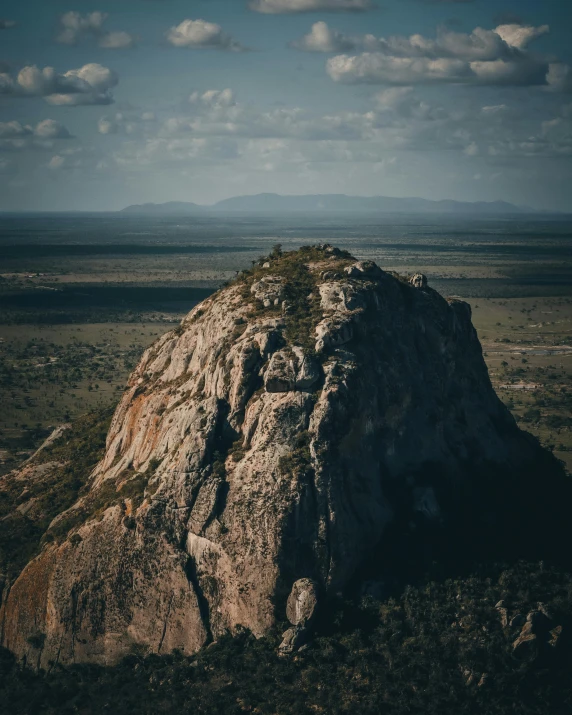 a large rock in the middle of an empty plain