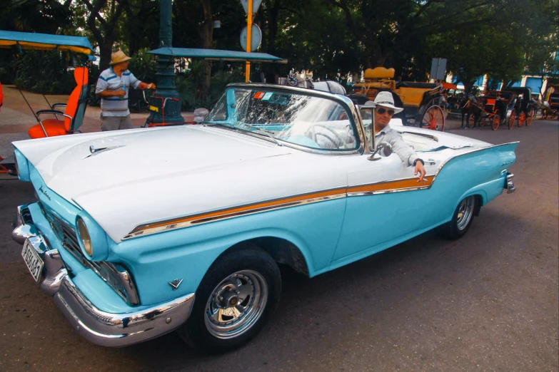 a blue and white car parked in a parking lot, a colorized photo, by Joe Bowler, pexels contest winner, carnaval de barranquilla, convertible, square, white and teal metallic accents