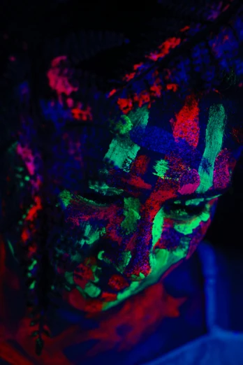 a man with black light on his face, an album cover, inspired by Elsa Bleda, trending on pexels, neo-fauvism, movie scene close up, woman portrait made out of paint, luminous veins, raver