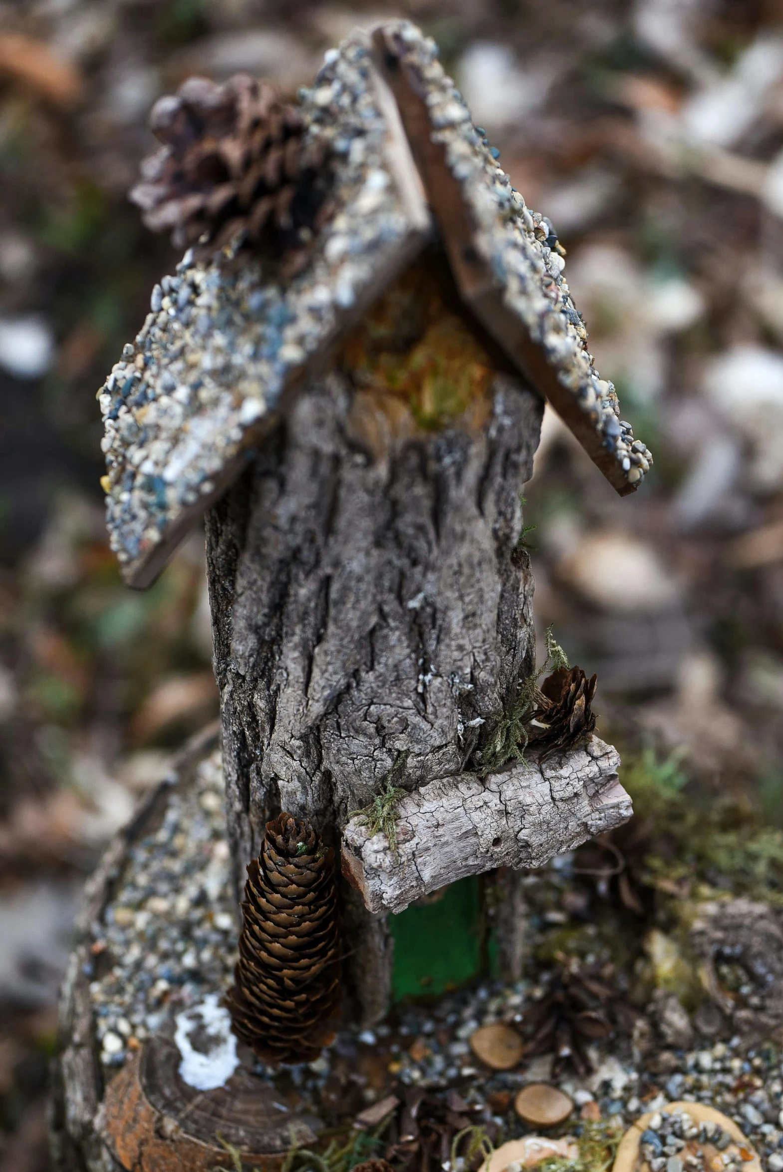 the small birdhouse is made out of logs and tree trunks