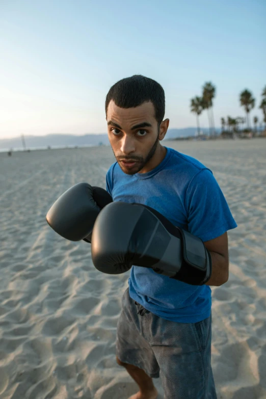 a man with a boxing glove on beach sand