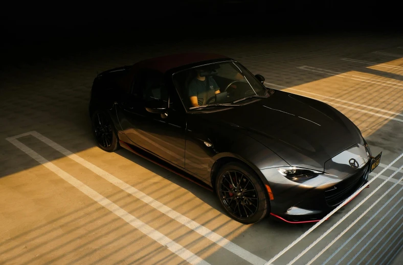 a dark and shiny mazda sports car is seen from above