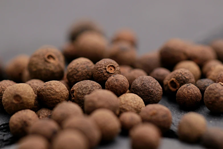 a pile of nutmeal sitting on top of a table, a macro photograph, by Carey Morris, unsplash, renaissance, pepper, spheres, brown:-2, jamaican