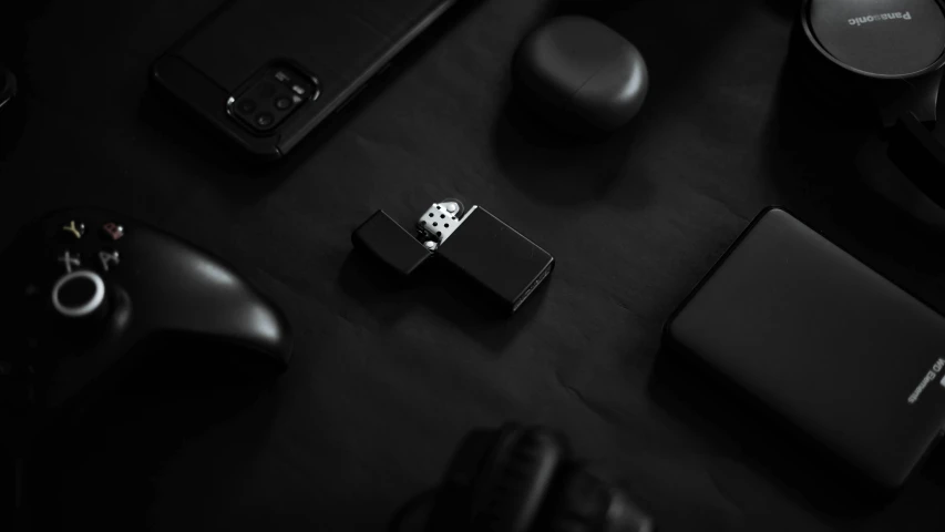 a group of electronics sitting on top of a table, a black and white photo, by Emma Andijewska, unsplash, minimalism, concept art zippo lighter, dark video game icon design, 4k/8k, wearing black