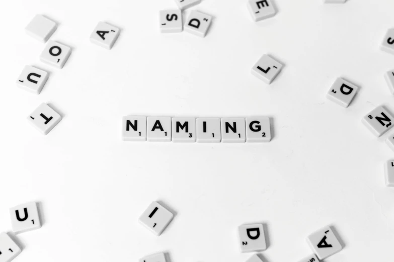 the word naming spelled in scrabbles on a white surface, an engraving, trending on pexels, neo-romanticism, award winning advertising, nanite, hacking into the mainframe, nipple