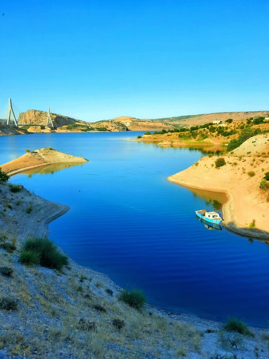 a body of water with a boat in it, dau-al-set, arrendajo in avila pinewood, in a desert oasis lake, slide show, river and trees and hills