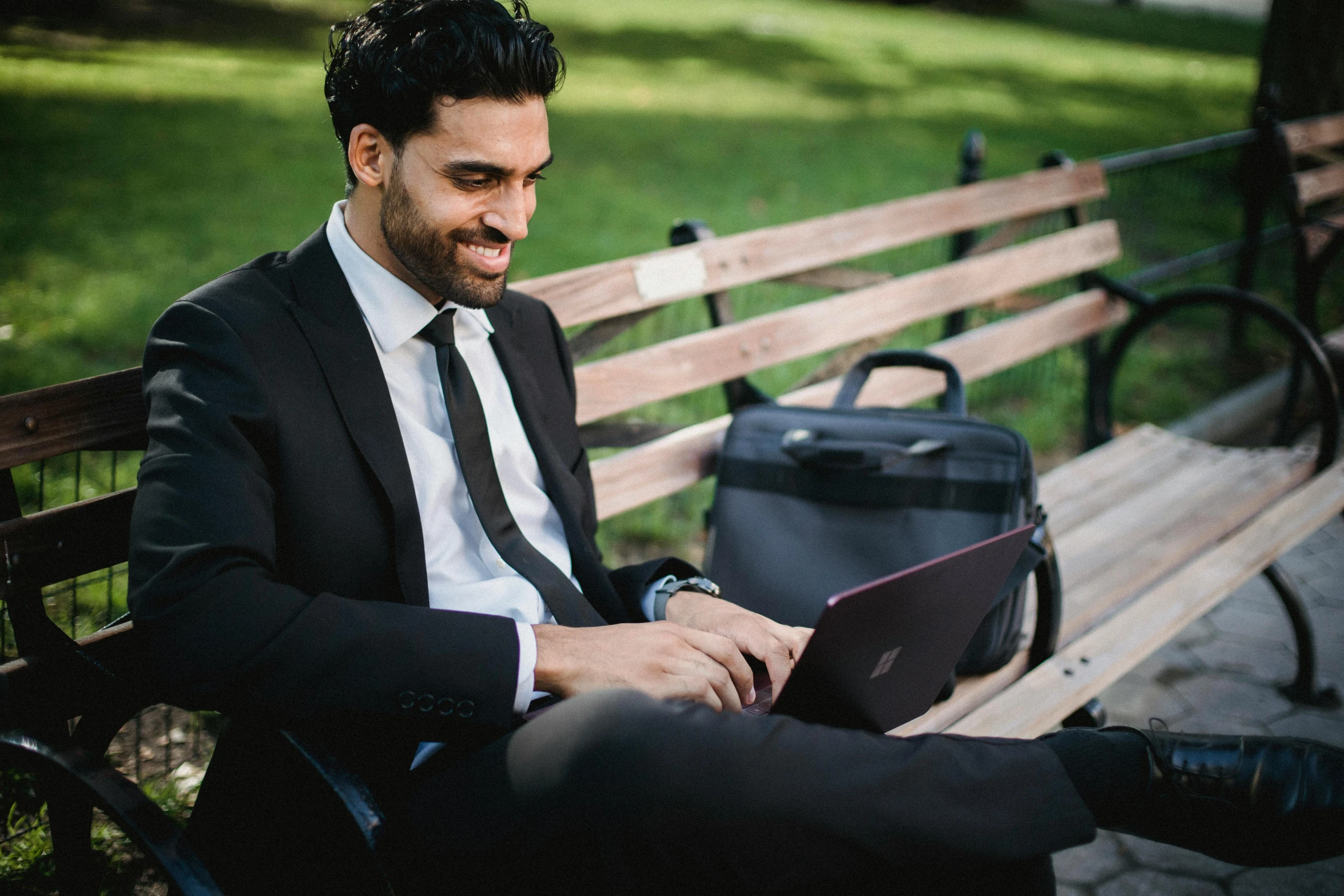 a man sitting on a bench using a laptop, pexels contest winner, wearing a suit and a tie, worksafe. instagram photo, sam nassour, sydney park