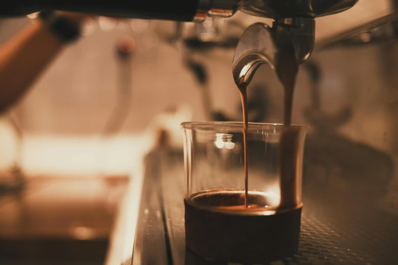 a cup of coffee being poured into a glass, by Daniel Lieske, pexels contest winner, renaissance, highly mechanical, close to night, slightly tanned, made of glazed