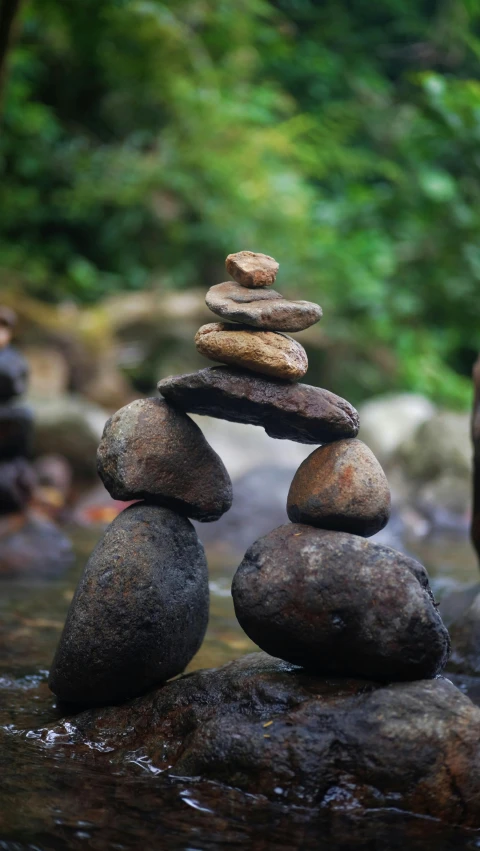 a pile of rocks sitting on top of a river, unsplash, land art, figurines, museum quality photo, brown, bali