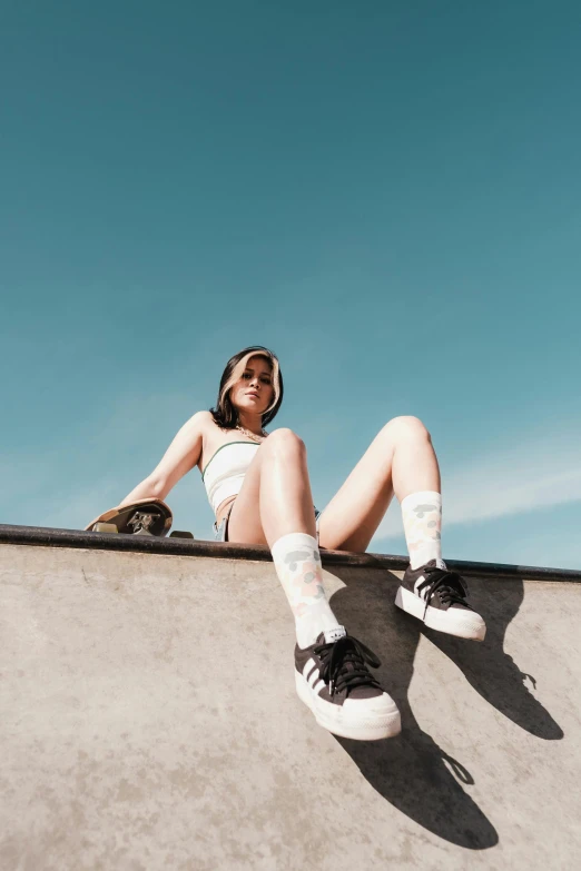 a woman sitting on top of a skateboard ramp, trending on pexels, bra and shorts streetwear, sunny clear sky, 5 0 0 px models, creamy