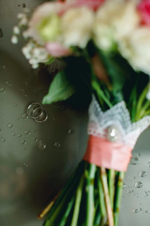 a bouquet of flowers sitting on top of a sink, rings, rain drops, jewlery