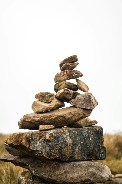 a pile of rocks stacked on top of each other, an abstract sculpture, by Jessie Algie, unsplash, land art, inuit heritage, ((rocks)), ascending, inuk