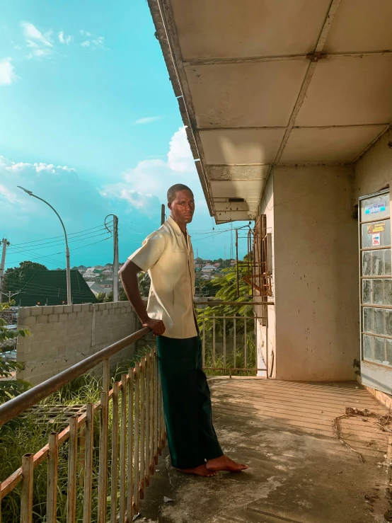 the man is posing outside on the balcony