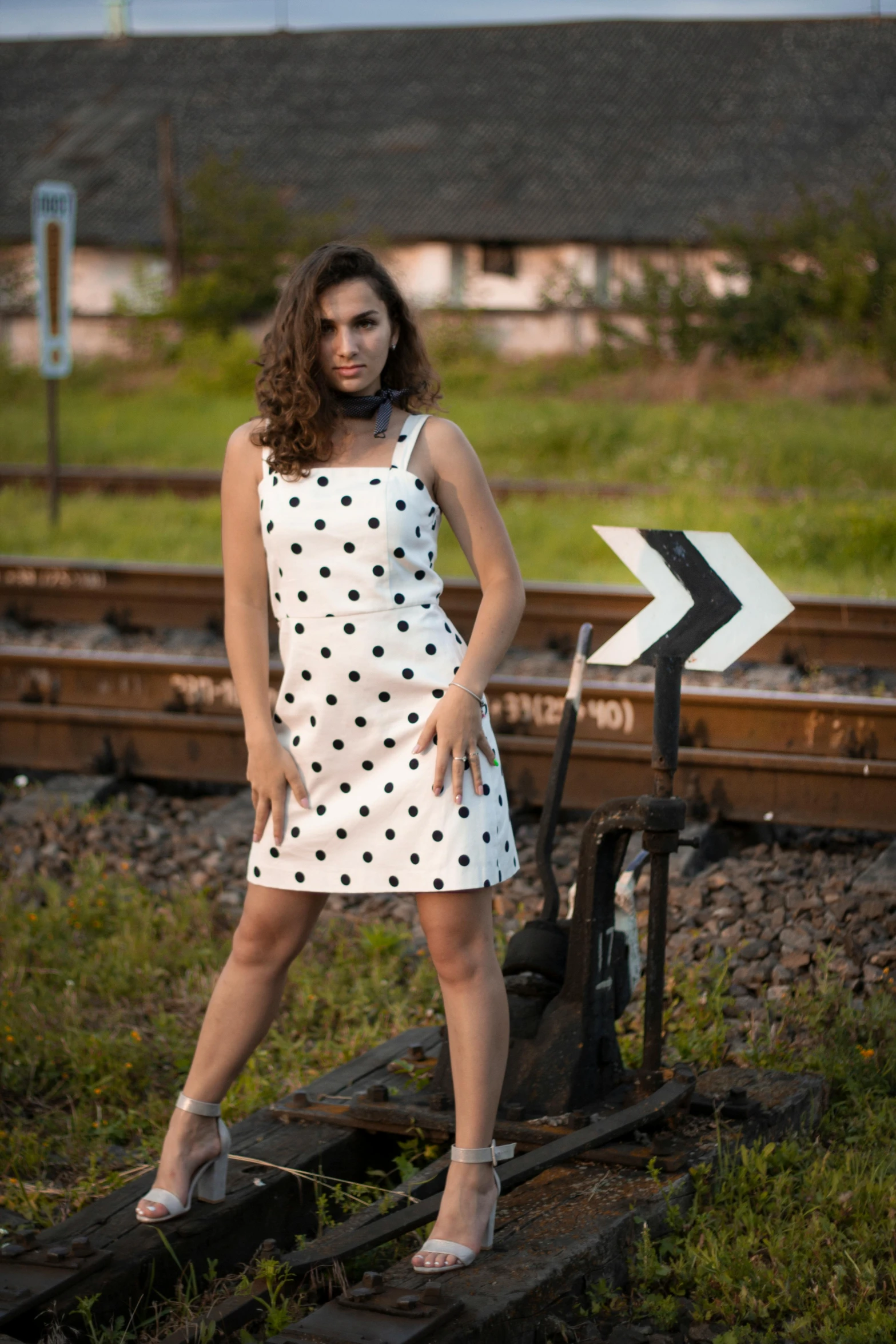 a beautiful young lady posing in front of train tracks