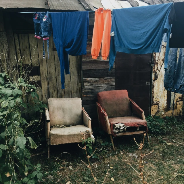 a couple of chairs sitting in front of a shack, pexels contest winner, arte povera, wet fabric, worn clothes, homes and gardens, 15081959 21121991 01012000 4k