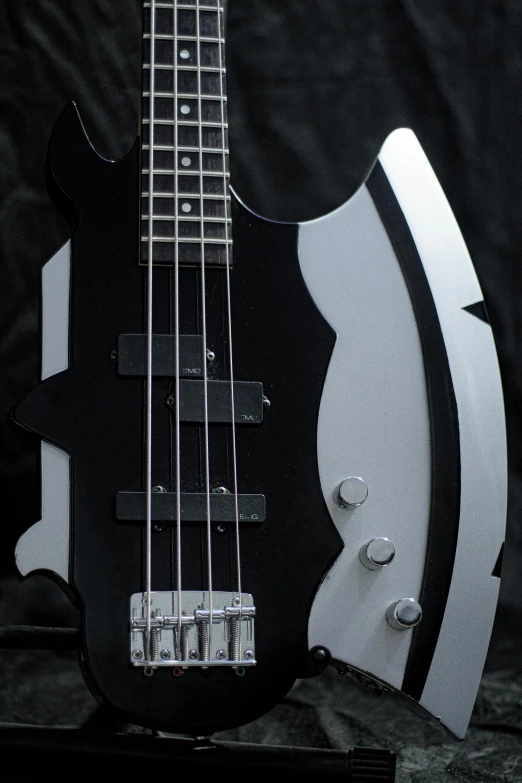 a close up of a black and white bass guitar, by Steve Prescott, reddit, conceptual art, streamlined matte black armor, grey metal body, symmetrical front view, metal bikini