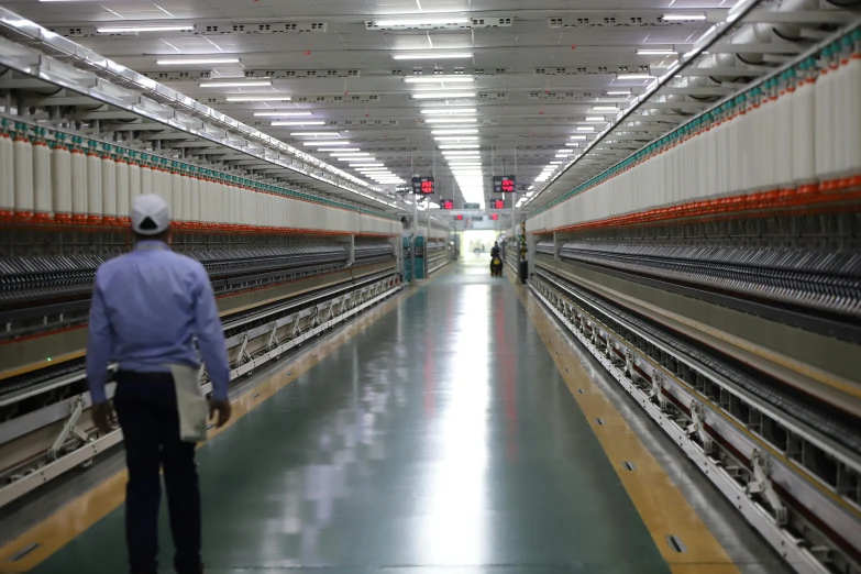 a man that is standing in front of a machine, inspired by Andreas Gursky, unsplash, gutai group, hou china, mill, walking towards camera, threads