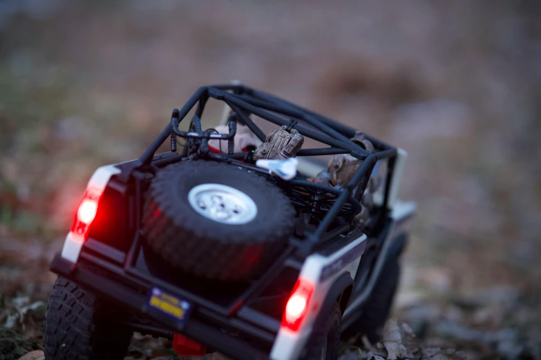 an off road toy car with the lights on and the tail light up