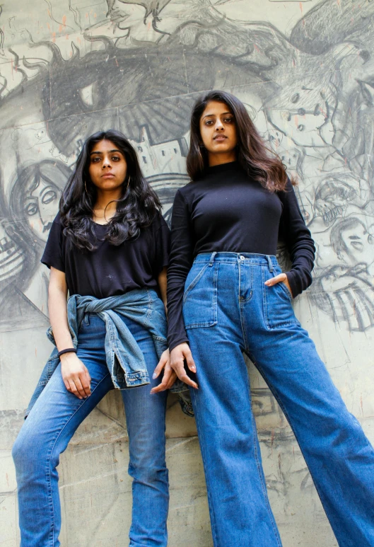 a couple of women standing next to each other, by Max Dauthendey, pexels contest winner, wearing a dark shirt and jeans, with a cool pose, trending on artstion, federation clothing