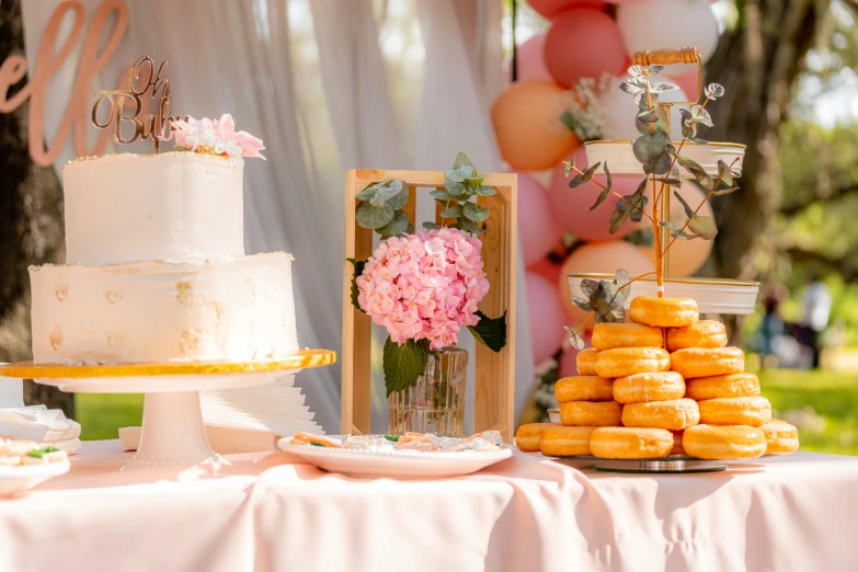 a table that has a bunch of desserts on it, by Liza Donnelly, pexels contest winner, pink and gold, beautiful daylight, birthday cake, donut