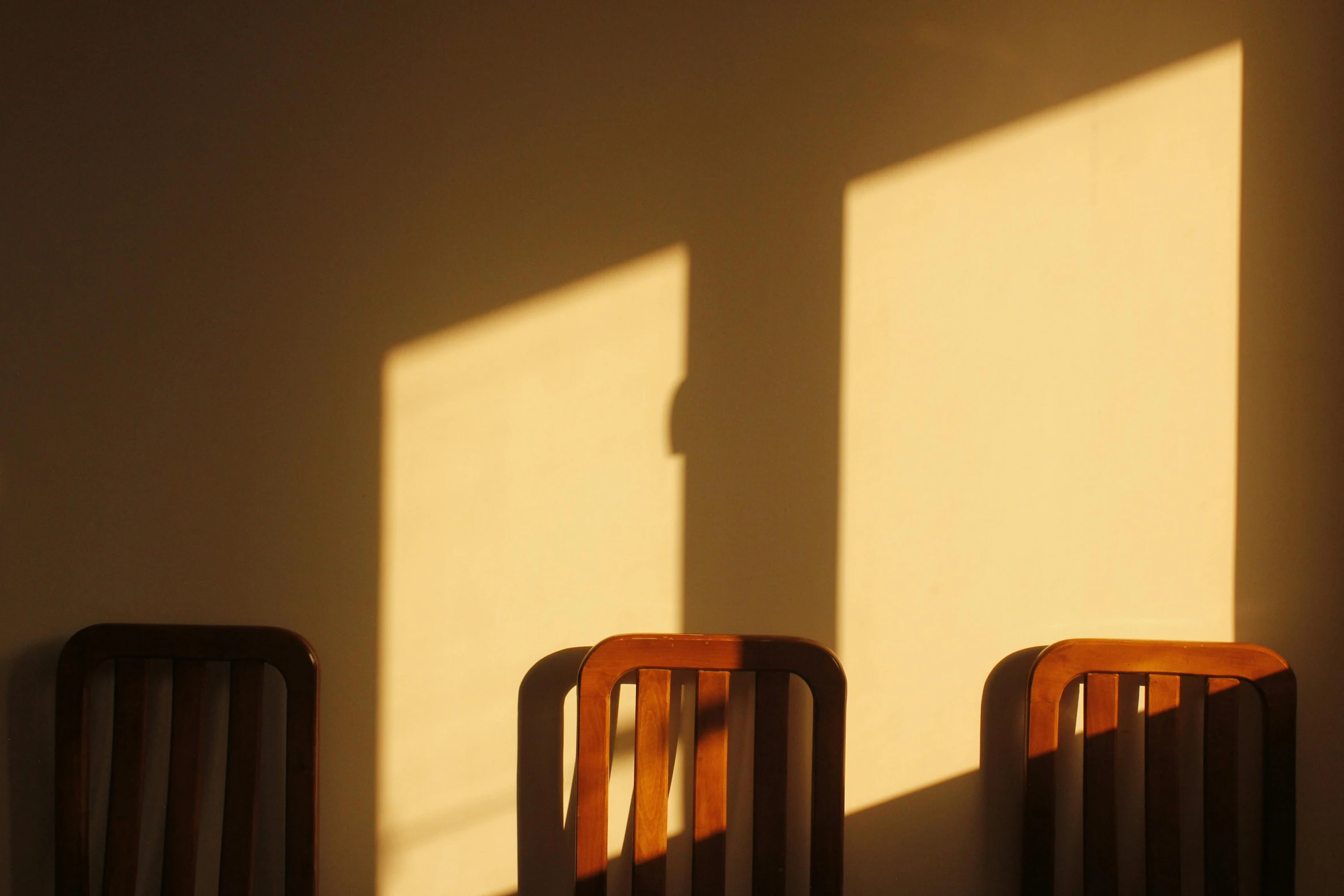 two chairs with the shadows of the opposite ones