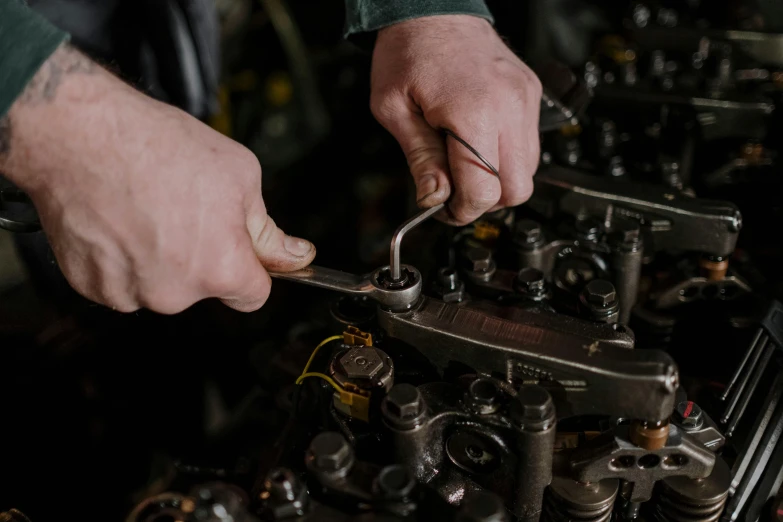 a close up of a person working on a car engine, by Frederik Vermehren, pexels contest winner, holding a crowbar, 15081959 21121991 01012000 4k, scrap metal on workbenches, upscaled to high resolution