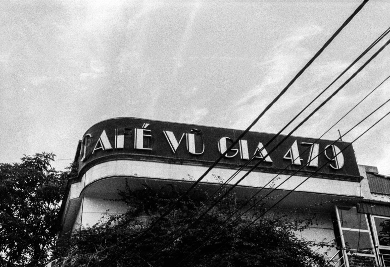 a black and white photo of a cafe, a black and white photo, by Pedro Álvarez Castelló, art nouveau, in chuquicamata, 4 0 years, view from ground, sign