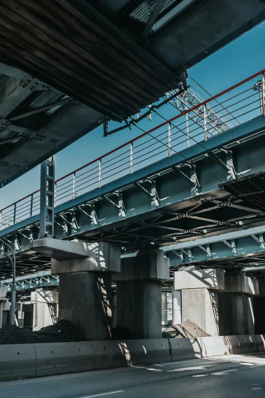 a man riding a motorcycle down a street next to a bridge, unsplash, graffiti, conveyor belts, view from below, executive industry banner, mechanical superstructure