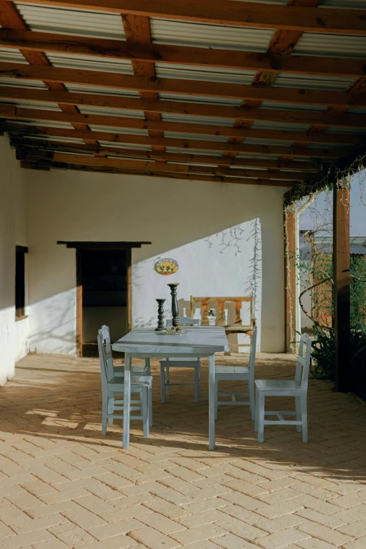 a patio with table, chairs and an umbrella