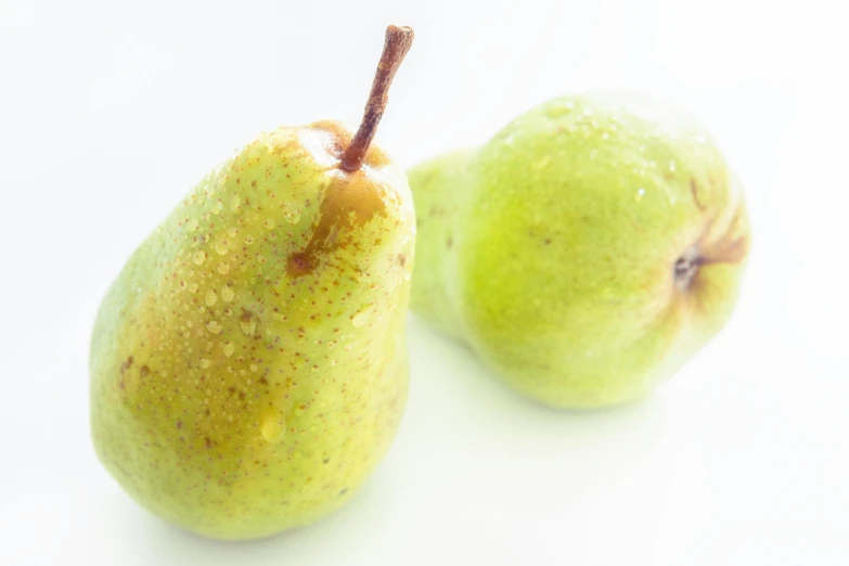 two green pears sitting next to each other on a white surface, by Gavin Hamilton, pexels, background image, 🐿🍸🍋