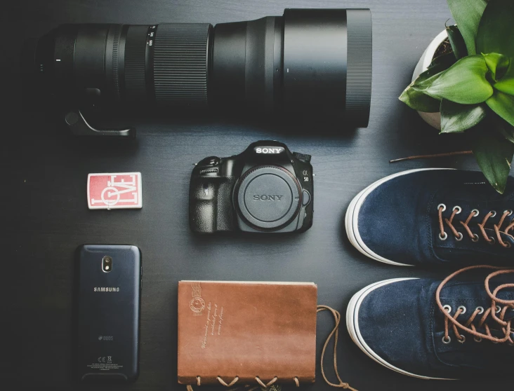 a camera sitting on top of a table next to a plant, pexels contest winner, traveling clothes, sneaker photo, computer wallpaper, all looking at camera