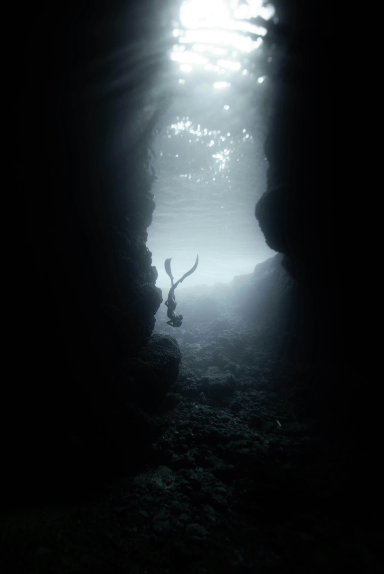 a person standing in the middle of a cave, inspired by Michal Karcz, unsplash contest winner, romanticism, swimming deep underwater, hawaii, silhouetted, taken in the late 2010s