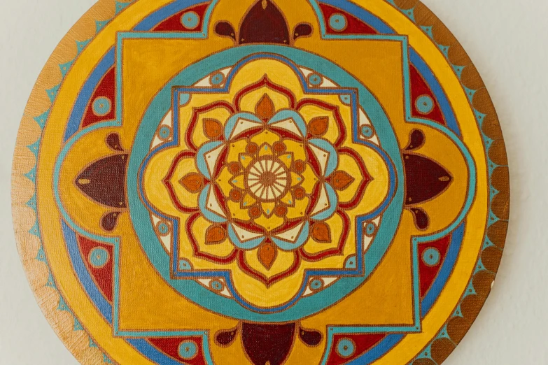 a close up of a decorative object on a wall, inspired by Ford Madox Brown, cloisonnism, lotus mandala, yellow, wood art, traditional painting