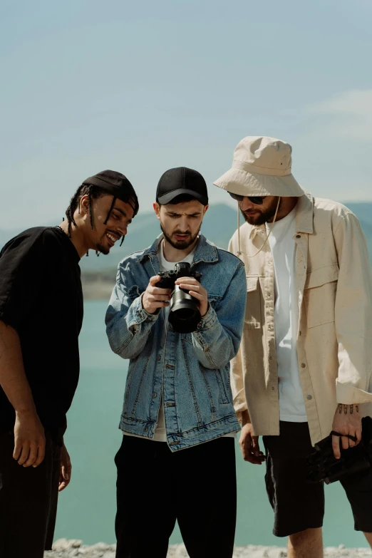 a group of men standing next to each other on a beach, a picture, pexels contest winner, visual art, rap scene, holding a camera, studio lit, developers