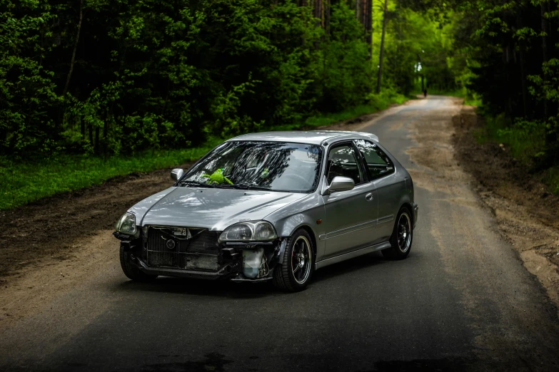 the silver car has been destroyed into pieces on a road