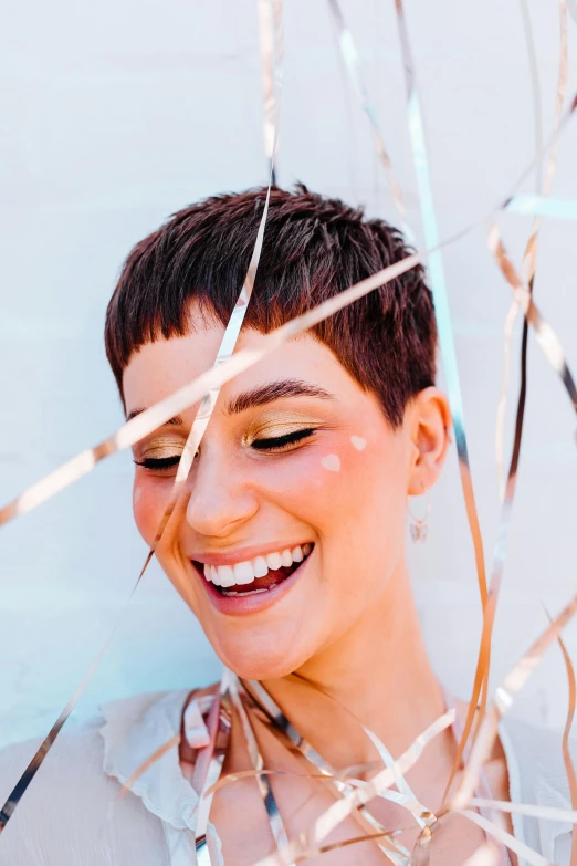 a close up of a person holding a cell phone, an album cover, by Julia Pishtar, pixie cut with shaved side hair, being delighted and cheerful, metallic flecks, happy friend