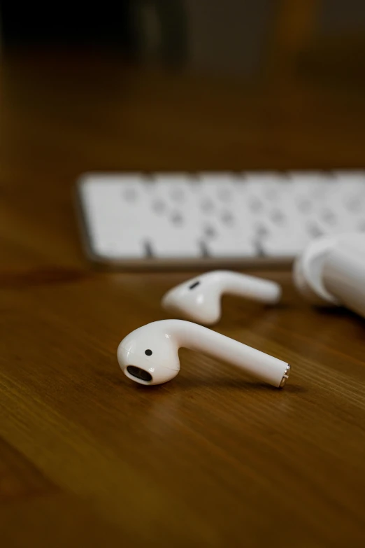 a pair of headphones sitting on top of a wooden table, by Julian Allen, unsplash, happening, airpods, toys, square, modeled