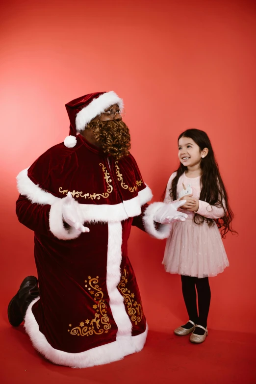 a child standing next to santa claus