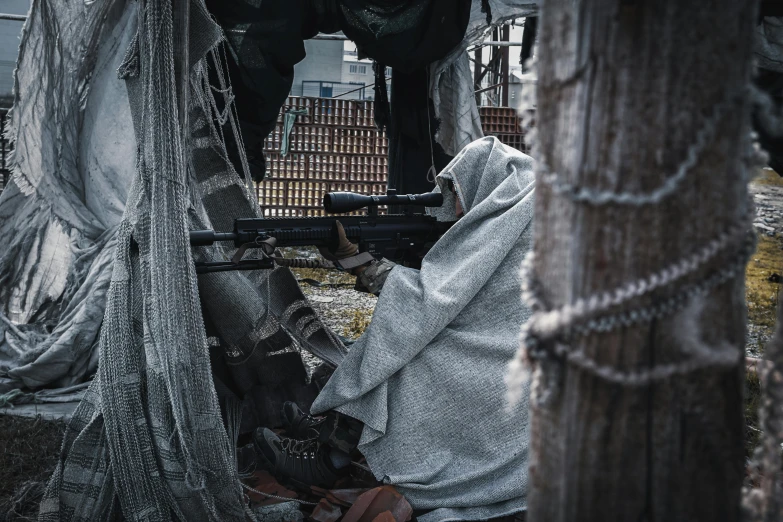 a man sitting in the back of a truck with a gun, by Adam Marczyński, unsplash contest winner, cloak covering face, in trenches, game ready, firing it into a building