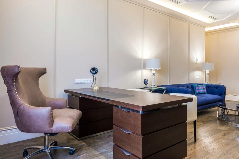 a purple office chair with an executive desk and a blue couch in the background