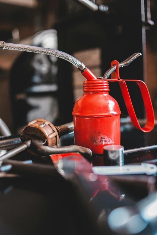 a red water bottle sitting on top of a table, by Adam Marczyński, pexels contest winner, auto-destructive art, restomod, watering can, profile image, hoses