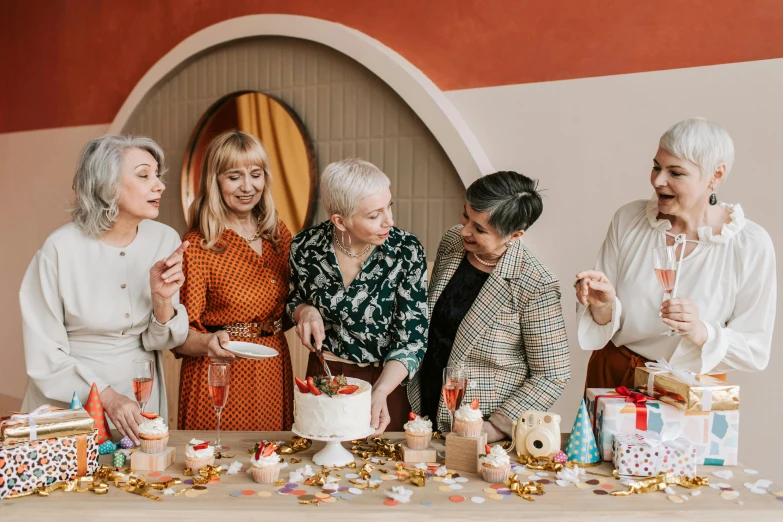 a group of women standing around a table with a cake, by Julia Pishtar, pexels contest winner, lots of wrinkles, 2506921471, indi creates, fashionable