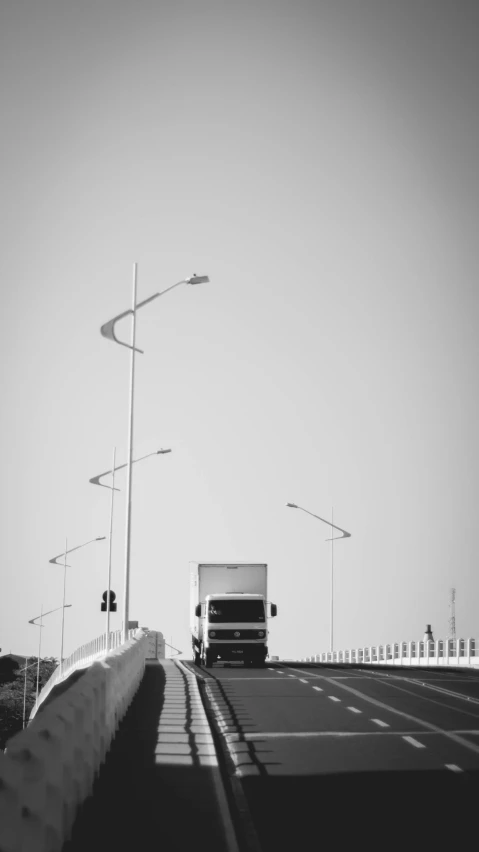 a black and white photo of a truck on a bridge, postminimalism, traffic light on, turkey, low quality photo, ::