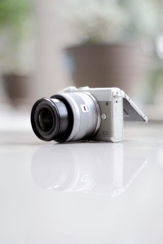 a white camera sitting on top of a table, a picture, shot with sony alpha, shot on nicon camera, micro lens, white and grey