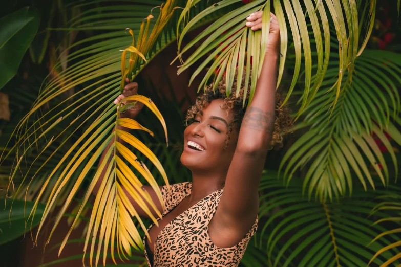 a woman in a leopard print swimsuit standing in front of palm leaves, pexels contest winner, figuration libre, smiling and dancing, ashteroth, thumbnail, in a tree