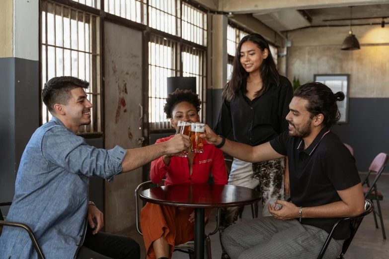 a group of people sitting around a table with drinks, four hands, modelling, supportive, brown