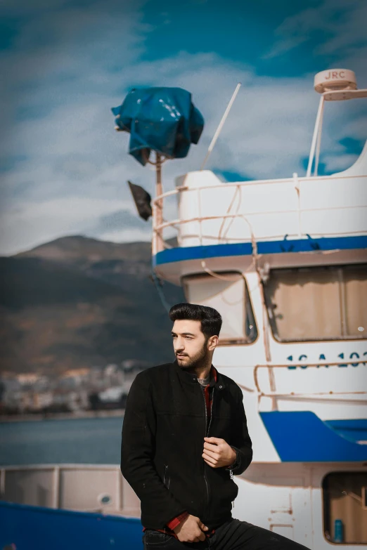 a man that is sitting down by a boat