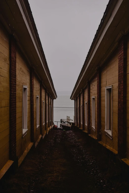 a walkway between two old buildings near the water