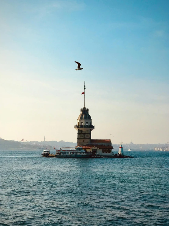 a bird flying over a large body of water, inspired by Niyazi Selimoglu, pexels contest winner, hurufiyya, neoclassical tower with dome, turkish and russian, 🚿🗝📝